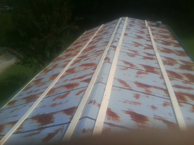 Rusted metal roof panels with new wood purlins before replacement — Storm Damage Roof Repair in Goochland by Roofing Brothers
