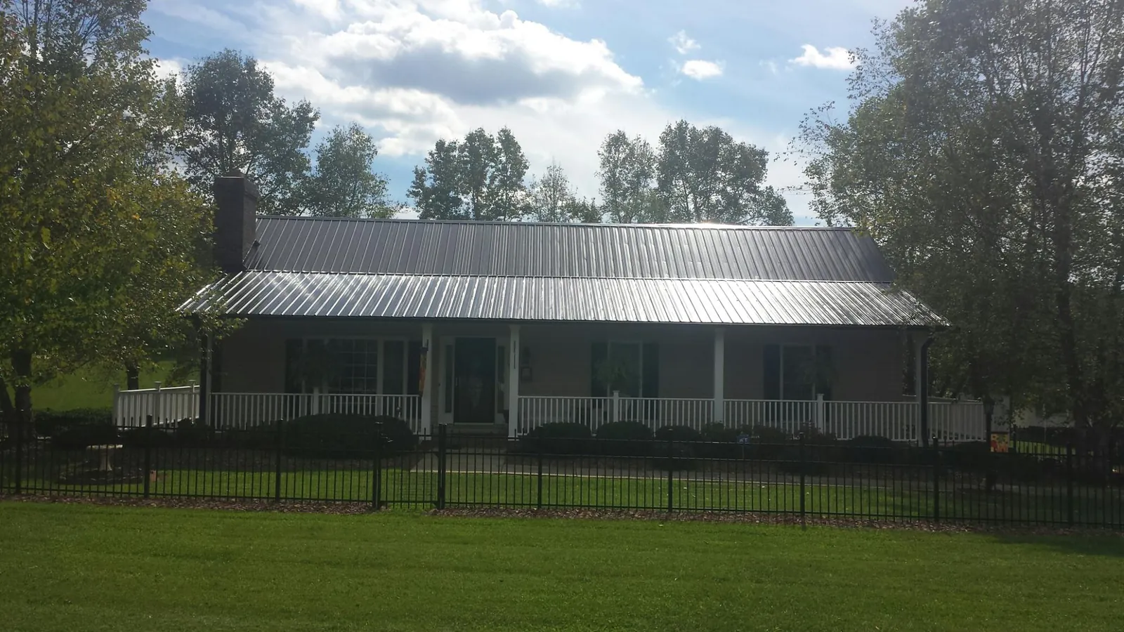 Gray metal roof on a brick ranch with a full width front porch — Gutter Guard Installation work by our crew in Goochland