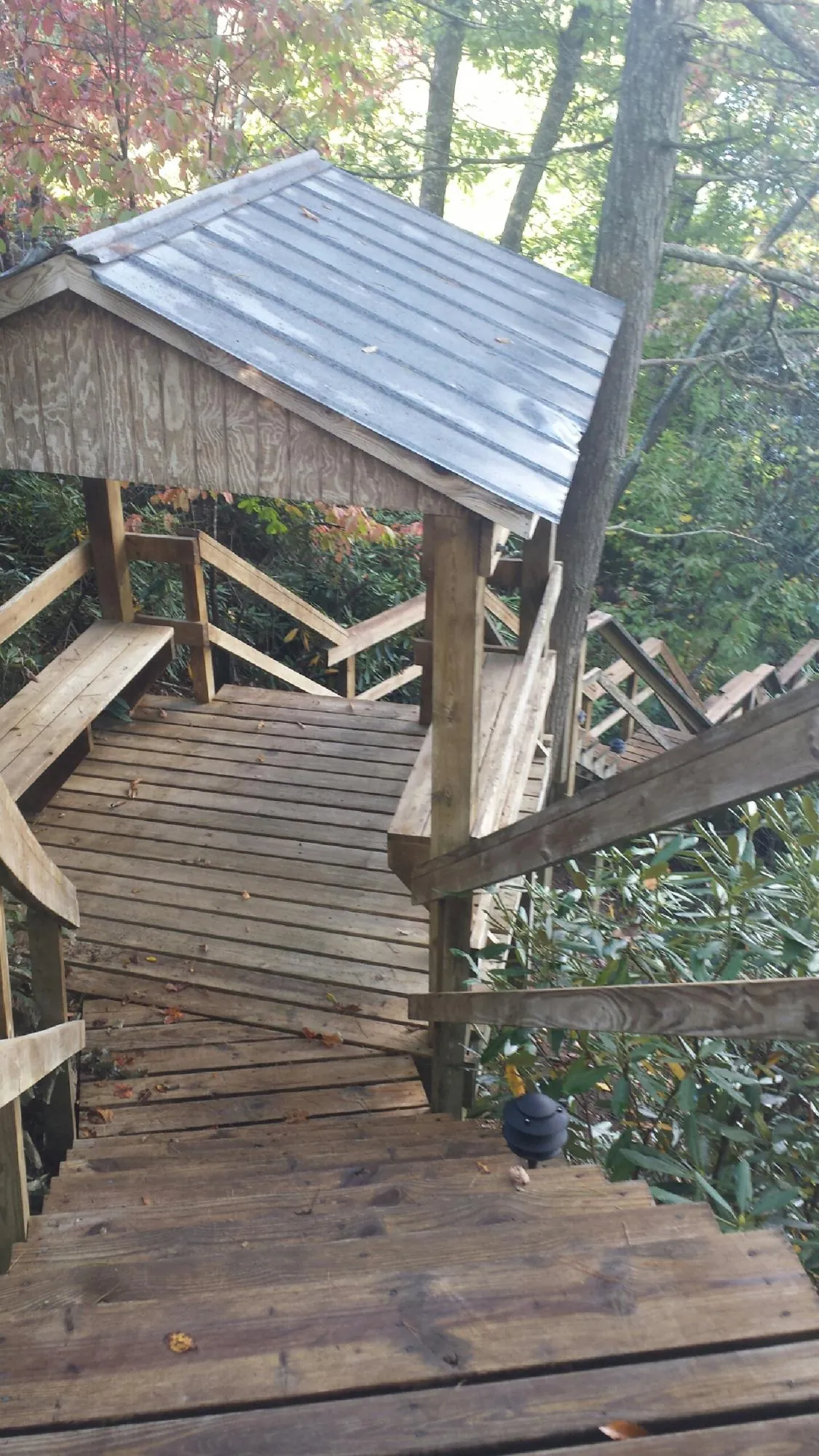 Metal roofed shelter over wooden steps on a wooded walkway — Skylight Repair & Installation work by our crew in Goochland