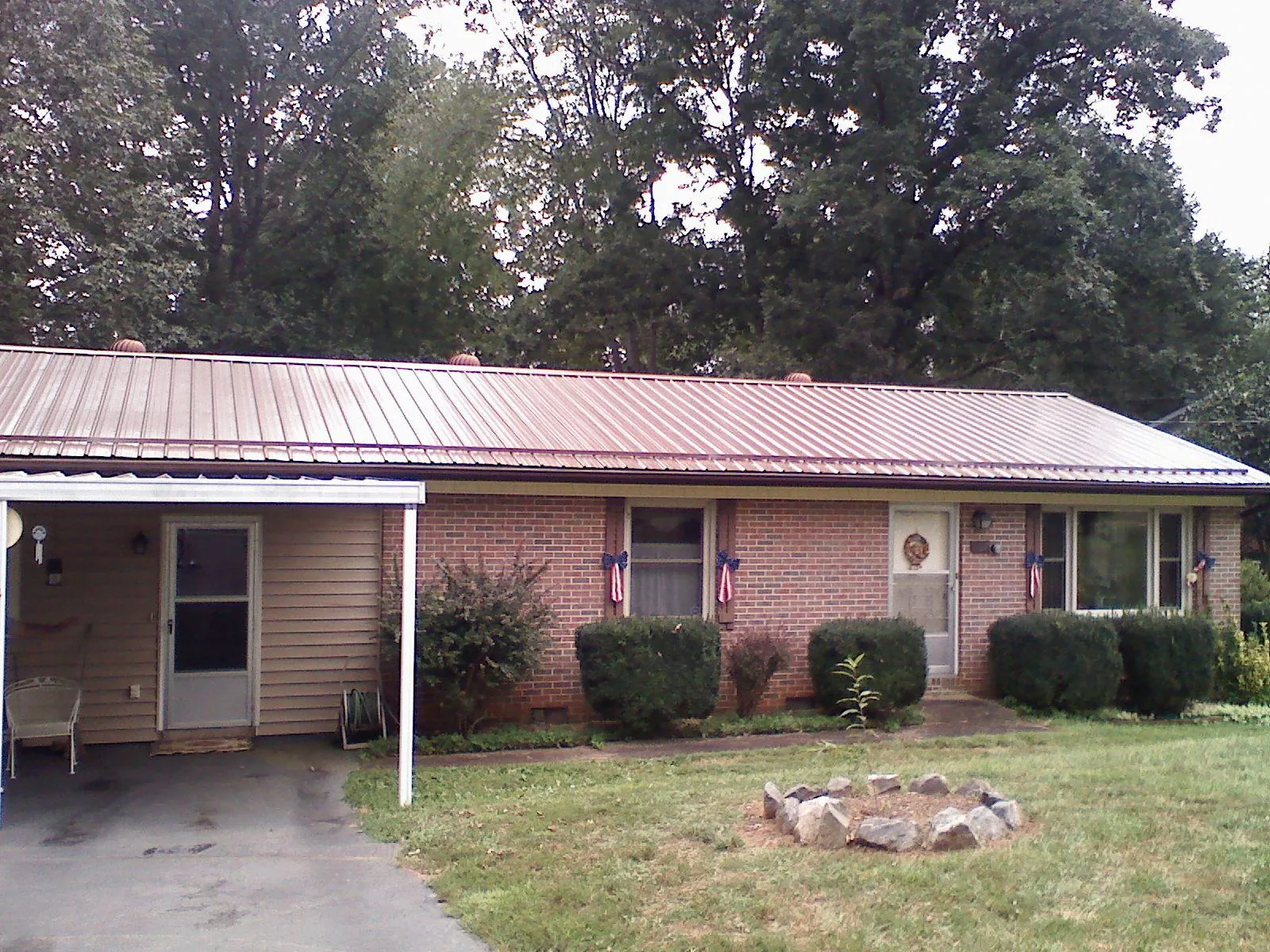 Bronze metal roof and carport on a brick ranch home — Roof Repair work by our crew in Goochland